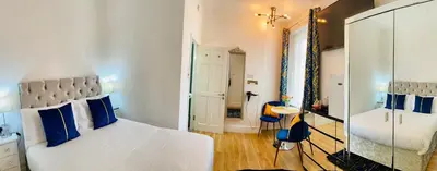 a bedroom with a bed with blue pillows and a mirror at Double Room with Private Bathroom Partial Tower view 16 Havelock Street - 5 in Blackpool