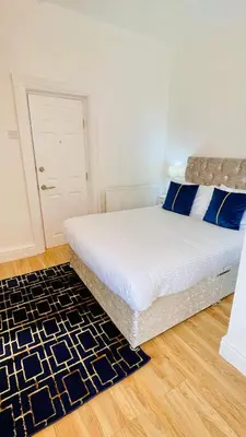 a white bed with blue pillows in a bedroom at Double Room with Private Bathroom Partial Tower view 16 Havelock Street - 5 in Blackpool