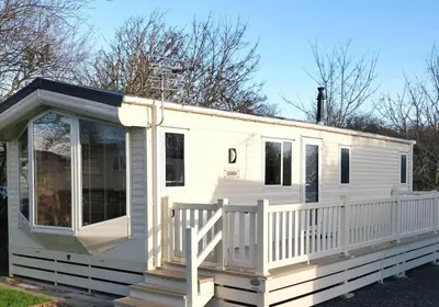 a white mobile home with a white porch at Parkview, Port Haverigg in Haverigg