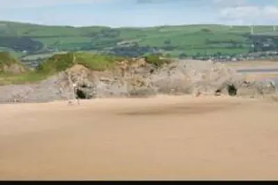 a view of a sandy beach with a field of grass at Parkview, Port Haverigg in Haverigg