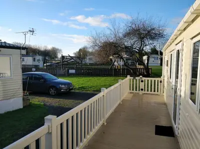 a porch of a house with a fence and a car at Parkview, Port Haverigg in Haverigg