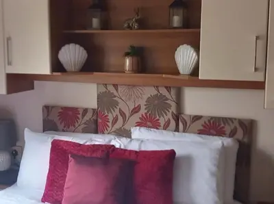 a headboard of a bed with red and white pillows at Parkview, Port Haverigg in Haverigg