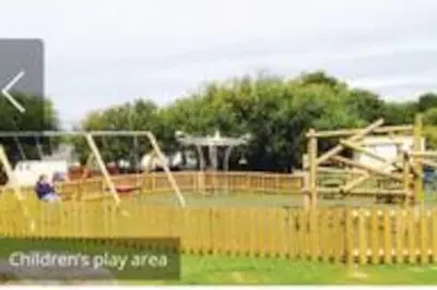 a childrens play area with swings and a playground at Parkview, Port Haverigg in Haverigg