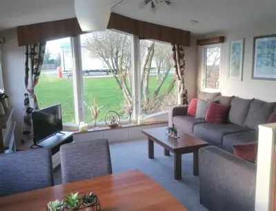 a living room with a couch and a table at Parkview, Port Haverigg in Haverigg