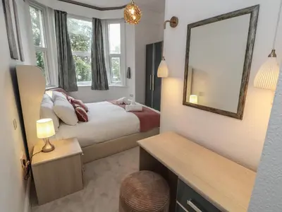 a bedroom with a large bed and a mirror at The Furness Haven in Barrow in Furness