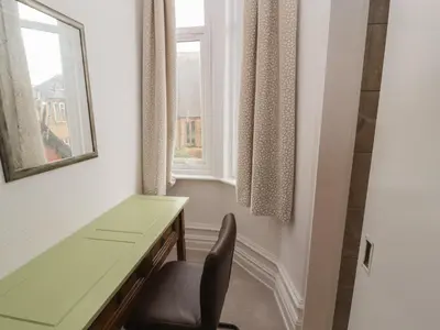 a desk and a chair in a room with a window at The Furness Haven in Barrow in Furness