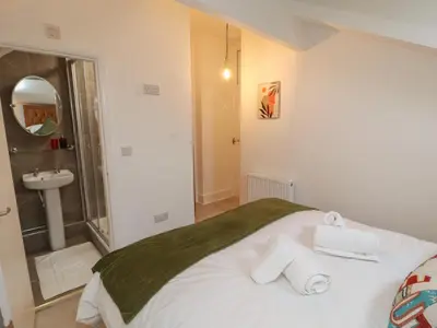 a bathroom with a bed and a sink with towels at The Furness Haven in Barrow in Furness