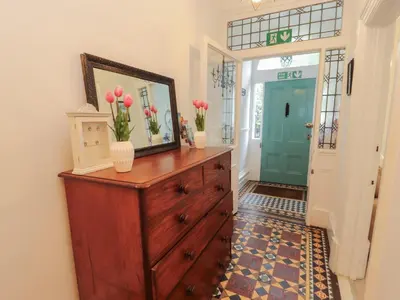 a room with a dresser with flowers on it at The Furness Haven in Barrow in Furness