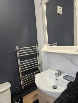 a bathroom with a sink and a mirror and a toilet at Blok 3 -Jacuzzi Suites, Apartment & Ensuite Rooms in Blackpool