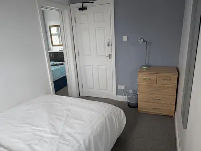 a bedroom with a bed and a dresser and a mirror at Blok 3 -Jacuzzi Suites, Apartment & Ensuite Rooms in Blackpool