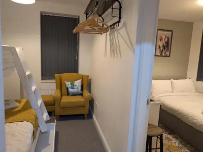 a bedroom with a bunk bed and a chair at Blok 3 -Jacuzzi Suites, Apartment & Ensuite Rooms in Blackpool