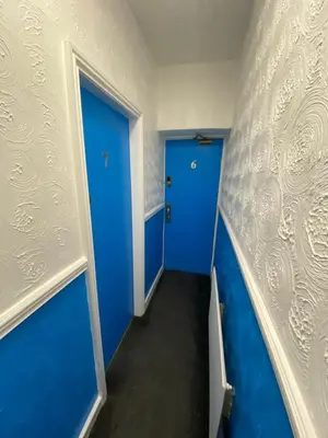 a hallway with blue walls and a blue door at The New ATLAS HOTEL in Blackpool