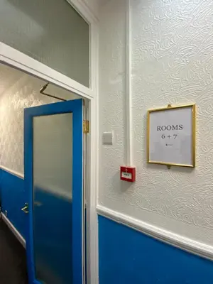 a room with a blue door and a sign on the wall at The New ATLAS HOTEL in Blackpool