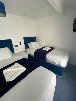 a room with three beds in a room at The New ATLAS HOTEL in Blackpool