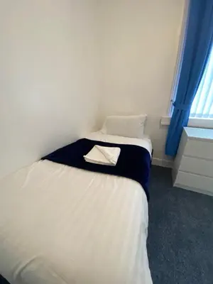 a small bedroom with a bed with a towel on it at The New ATLAS HOTEL in Blackpool