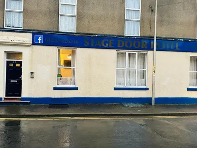 a building with a blue sign on the side of it at The Stage Door Hotel in Blackpool
