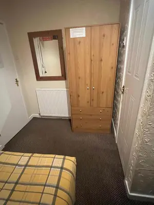 a bedroom with a bed and a wooden door at The Stage Door Hotel in Blackpool