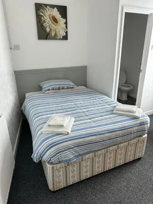 a bed in a bedroom with a flower on the wall at The Stage Door Hotel in Blackpool