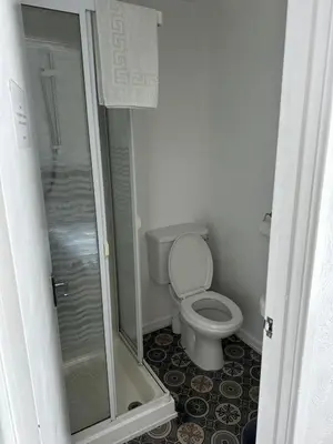 a small bathroom with a toilet and a shower at The Stage Door Hotel in Blackpool