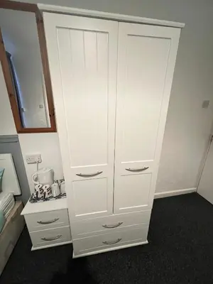 a tall white cabinet in a room with a stove at The Stage Door Hotel in Blackpool