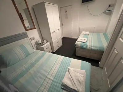a small bedroom with two beds and a mirror at The Stage Door Hotel in Blackpool