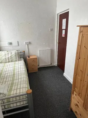a bedroom with a bed and a wooden door at The Stage Door Hotel in Blackpool