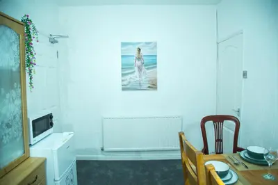 a dining room with a table and a picture on the wall at Lucky Home 24 - Ideal for Trade & Family - 2 Bedrooms - 3 Beds - Max 4 Guests - Close to BAE, Docks, Lake District, Beaches in Barrow in Furness