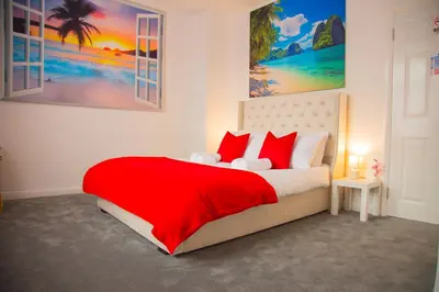 a bedroom with a large bed with red pillows at Lucky Home 24 - Ideal for Trade & Family - 2 Bedrooms - 3 Beds - Max 4 Guests - Close to BAE, Docks, Lake District, Beaches in Barrow in Furness