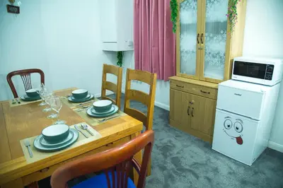 a kitchen with a table and chairs and a microwave at Lucky Home 24 - Ideal for Trade & Family - 2 Bedrooms - 3 Beds - Max 4 Guests - Close to BAE, Docks, Lake District, Beaches in Barrow in Furness
