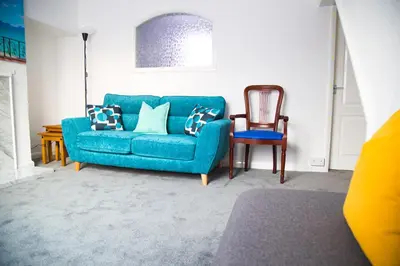 a blue couch and a chair in a living room at Lucky Home 24 - Ideal for Trade & Family - 2 Bedrooms - 3 Beds - Max 4 Guests - Close to BAE, Docks, Lake District, Beaches in Barrow in Furness