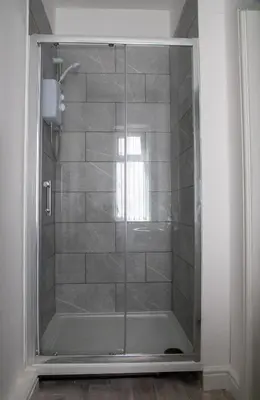 a shower with a glass door in a bathroom at Ground Floor - Balmoral Stays - Free Wifi in Blackpool