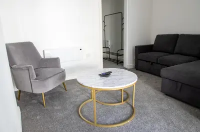 a living room with a chair and a coffee table at Ground Floor - Balmoral Stays - Free Wifi in Blackpool