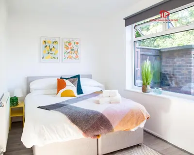 a bedroom with a bed and a window at Spacious 7-Bed Home for Contractors & Families in St Helens in Saint Helens