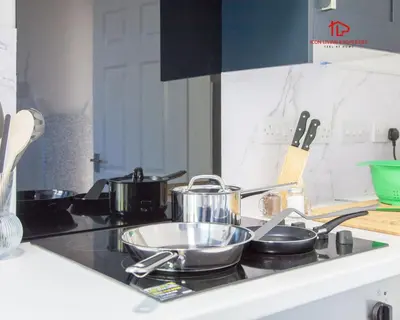 a kitchen counter with pots and pans on a stove at Spacious 7-Bed Home for Contractors & Families in St Helens in Saint Helens