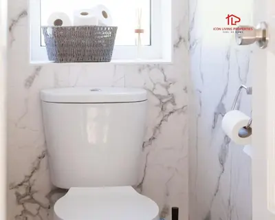 a white toilet in a bathroom with marble walls at Spacious 7-Bed Home for Contractors & Families in St Helens in Saint Helens