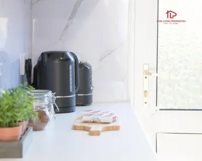 a kitchen counter with a coffee maker and towels at Spacious 7-Bed Home for Contractors & Families in St Helens in Saint Helens