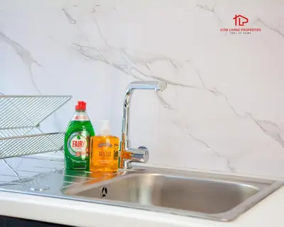 a kitchen sink with a bottle of cleaning agent next to it at Spacious 7-Bed Home for Contractors & Families in St Helens in Saint Helens