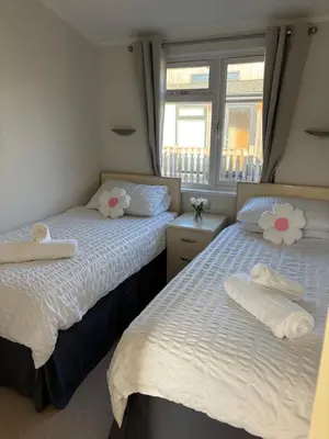 two beds in a bedroom with towels on them at Gressingham 9 - South Lakes Leisure Village - lodge on the lake in Carnforth