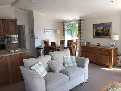 a living room with a couch and a kitchen at Gressingham 9 - South Lakes Leisure Village - lodge on the lake in Carnforth