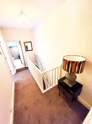 a room with a staircase with a lamp on a table at Quakers Field View in Pennington