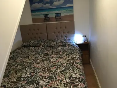 a bedroom with a bed with two chairs on it at Millbrook by the sea in Wallasey