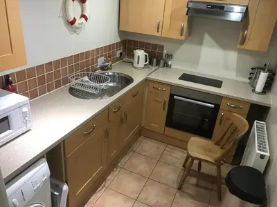 a small kitchen with a sink and a stove at Millbrook by the sea in Wallasey