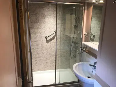 a bathroom with a glass shower and a sink at Millbrook by the sea in Wallasey