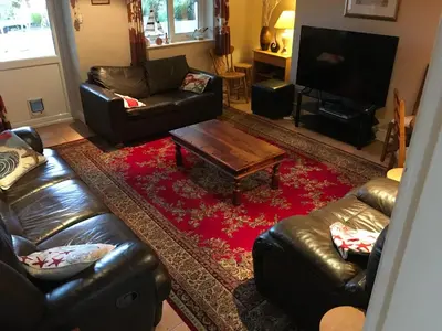 a living room with leather couches and a coffee table at Millbrook by the sea in Wallasey