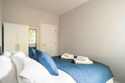 a bedroom with a bed with blue and white pillows at Modern 1 Bed Apartment in Waterloo Liverpool in Liverpool
