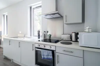 a white kitchen with a stove and a microwave at Modern 1 Bed Apartment in Waterloo Liverpool in Liverpool
