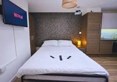 a large bed in a room with a tv on the wall at Stylish City Escape near Cavern Quarter sleeps 4 in Liverpool