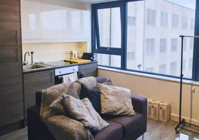a living room with a couch in front of a kitchen at Stylish City Escape near Cavern Quarter sleeps 4 in Liverpool