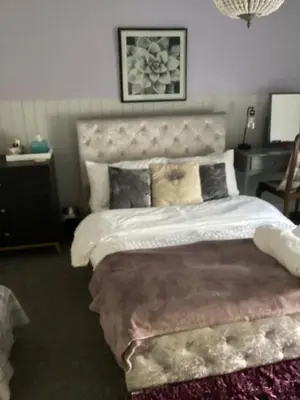 a bedroom with a large bed with a large headboard at The lavender house 513 halliwell rd bolton bl18db in Bolton