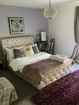 a bedroom with a large bed and a desk at The lavender house 513 halliwell rd bolton bl18db in Bolton